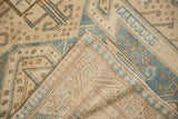 The hand-knotted foundation and secure machine-bound edge of a vintage distressed Oushak rug.