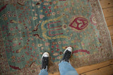 Low-pile texture with bird and palmette motifs on a distressed Persian rug.