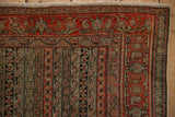 Faded brick red border of antique Senneh rug, floral vines, and striped field pattern.