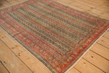 Persian antique Senneh rug corner with faded brick red border and parallel vine field.