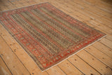 Detail of antique Persian Senneh rug, faded brick red border with intricate Herati Mahi vines.