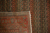 Antique Senneh rug corner with fringe, highlighting parallel vine patterns in faded brick red and olive.