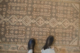 Time-softened wear on the geometric floral gul pattern of a distressed Hamadan rug.