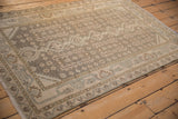 Angled detail of a distressed Hamadan rug's even wear and geometric floral motifs.