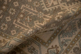 Softly folded vintage Persian rug showing the even wear and texture of its hand-knotted pile.