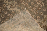 A folded corner of the vintage Hamadan rug reveals its hand-knotted foundation and secured edge.