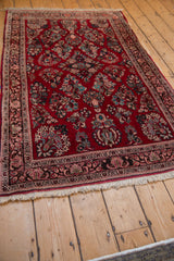 Corner detail of the vintage Sarouk rug, showing beige fringe and vibrant floral sprays.