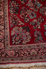 Vintage Sarouk rug with an intact fringed end and ornate floral border.