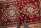 A look down at the vintage Caucasian rug's abrashed field and soft, distressed texture.