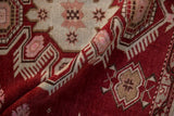 Visible knot heads on a distressed Caucasian rug with pink and rust geometric motifs.