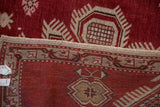 Hand-knotted weave and distressed rust-red pile of a vintage Caucasian rug.