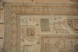 Corner view of a distressed Afshar rug showing its intact selvage and time-softened low pile.