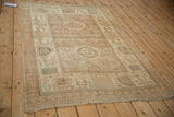 Angled view of a distressed Afshar rug's geometric border and evenly worn texture.