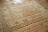 Angled view of a distressed Afshar rug showing its soft, time-worn texture and geometric patterns.
