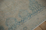 Low pile texture of a distressed Afshar rug showing faded blue motifs and visible foundation.
