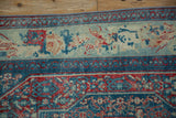 Corner view of the Senneh rug's floral border showing time-softened wear to the knot heads.