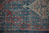 Stepped relief and arrowed finials in cherry red and cobalt blue on a distressed rug.