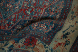 Softly draped vintage Senneh rug showing distressed texture and intricate cobalt blue and red Herati design.