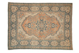 Vintage distressed Tabriz rug with faded terracotta scalloped medallion and navy floral vines.