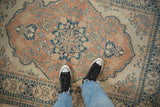 Vintage distressed Tabriz rug with faded peach, dusty blue floral design and soft worn pile.