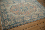 Distressed Tabriz rug close-up: intricate floral vines in sapphire blue and terracotta.