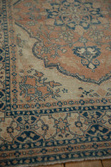 Intricate floral pattern on distressed Tabriz rug in dusty navy, soft terracotta, and ivory.