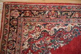 Corner floral spandrels and intricate borders of a vintage Persian Sarouk rug.