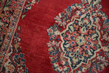 Detailed floral spray in blue, rose, and beige on a vintage Sarouk's cherry red field.