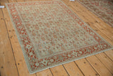 Distressed vintage Senneh rug with an allover Herati pattern in rust and ivory on a silver-teal field.