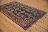 Kurdish Hamadan rug corner, showing blush serrated border, geometric boteh, and navy field.