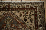 Corner of a vintage Hamadan rug, showing softened grey field, ivory fringe, and burgundy patterns.