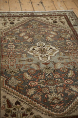 Angled view: distressed Hamadan rug with muted Herati field and light floral medallion.