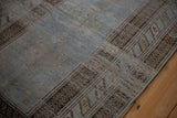 Mostly even wear and low pile texture on a vintage Belouch rug in pale denim blue and charcoal brown.