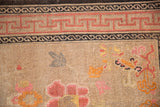 Antique Ningxia rug: pink reciprocating running-T border, charcoal accents, blooming field.
