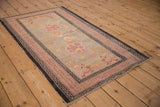 Antique Chinese Ningxia rug corner, pink running-T border, and beige floral field.