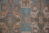 Detail of the hand-knotted texture showing mostly even wear and geometric floral motifs.