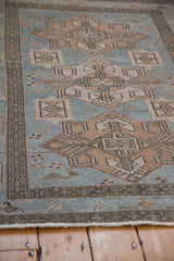 Low-pile texture and meandering vine border on a distressed vintage Persian Hamadan rug.