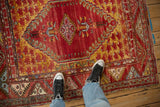 Vintage Anatolian rug with cherry red field, floral cross section spandrel, and geometric border.