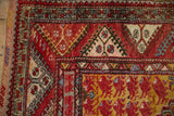 Vintage Anatolian rug corner, showing floral spandrel and geometric gul border in red, saffron, and ivory.