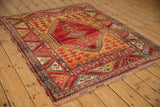 Vintage Anatolian rug corner with cherry red geometric border and saffron yellow field.