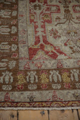Distressed pile showing pawn motifs in the coffee brown border of a vintage Anatolian rug.
