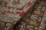 Close-up of the hand-knotted texture and worn pile of a distressed Anatolian rug in coffee brown and cherry red.