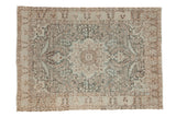 Vintage distressed Tabriz rug with a starburst medallion and floral field in dusty teal, powder blue, and soft browns.