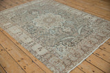 Angled view of a vintage Tabriz rug's interconnected floral and vine pattern in dusty teal and beige.