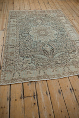 Side perspective of a vintage Tabriz rug showing its soft, distressed texture and floral pattern.