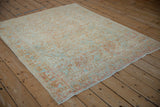 Angled view of a vintage Afshar rug, highlighting the soft wear and pastel boteh field pattern.