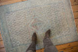 A view looking down at a distressed vintage Arak rug for scale.