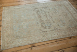 Vintage distressed Meshed rug's machine-bound side with faded powder blue and ivory design.