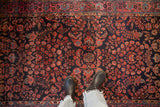 Short pile texture and intricate floral sprays of a hand-knotted antique Persian Mohajeran Sarouk rug.