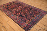 Angled view of an antique Mohajeran Sarouk rug showing intricate floral sprays and bouquets.